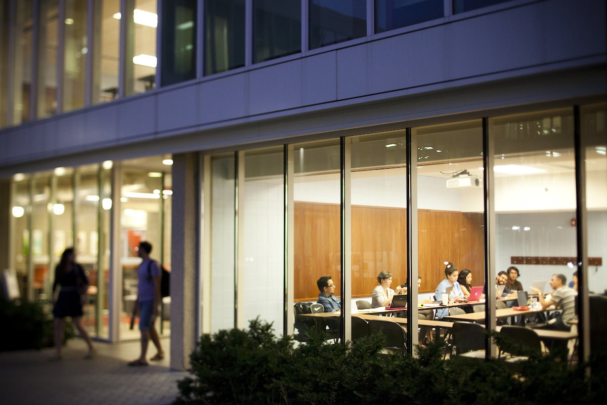 an image of a lit classroom at night from the outside