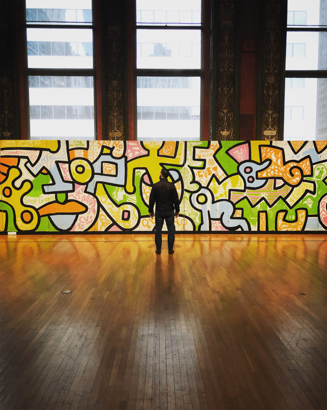 Person in front of Keith Haring Painting